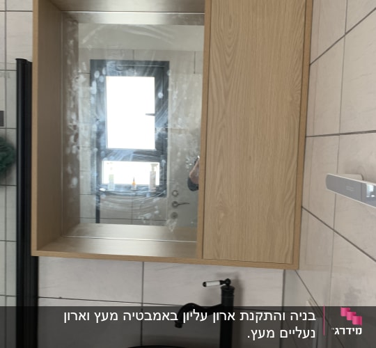 ארון עץ עם מראה מעל כיור שחור